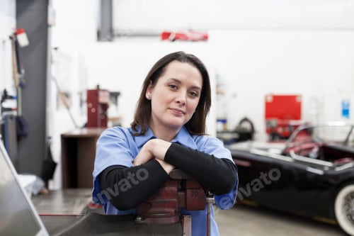 Preview: A portrait of a caucasian female mechanic in a car repair shop.