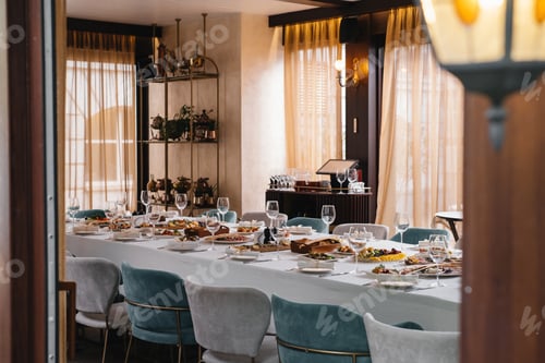 Preview: Glasses and plates on long table in restaurant for celebration