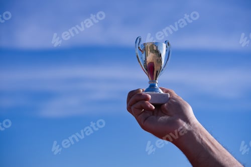 Preview: Male hand holds a silver cup.
