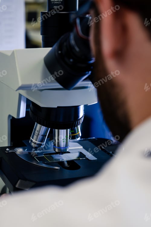 Preview: A laboratory worker working with a modern microscope while conducting a coronavirus research