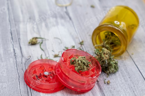 Preview: medical marijuana buds and a red plastic grinder