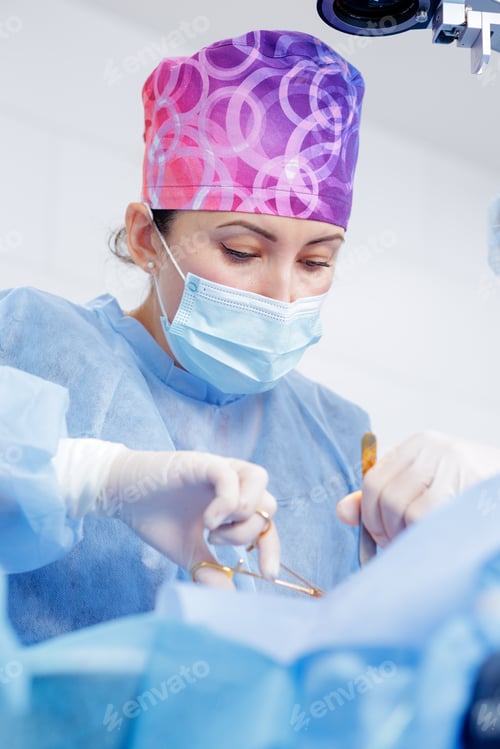 Preview: Female Surgeon in Operating Room Wearing Surgical Mask