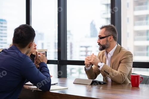 Preview: Businessman discussing project with team colleagues in the office