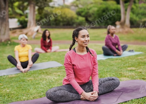 Preview: Group of diverse women doing yoga exercise at city park