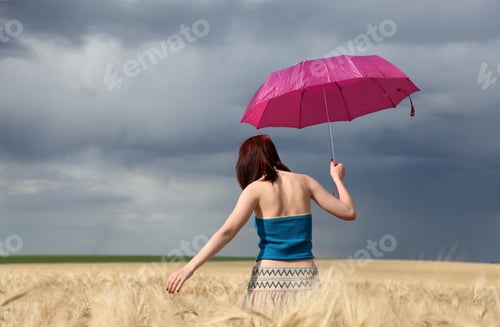 Preview: Girl with umbrella at wheat field at rainy day