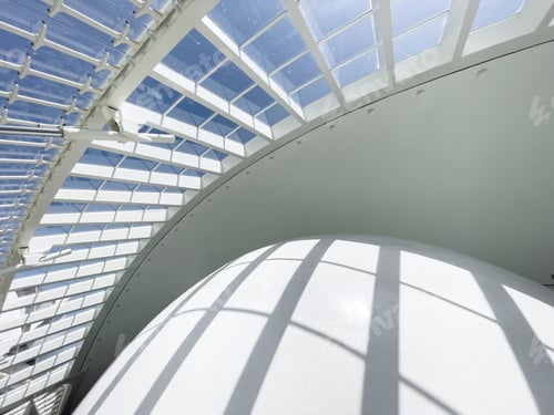 Preview: Photograph of a modern architectural building. Sunlight shines through the glass and casts shadows.