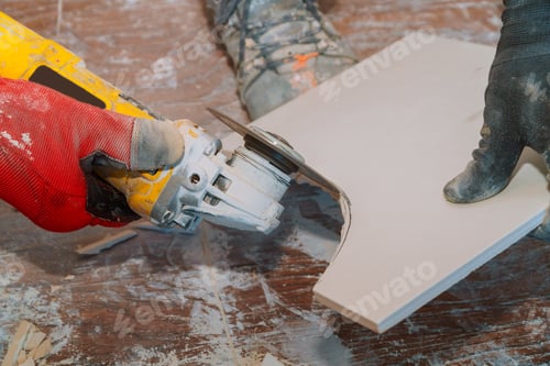 Preview: Worker using grinder tool to cut tile with dust in renovation bathroom