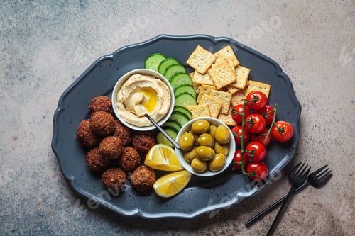 Preview: Falafel platter with hummus, olives, crackers and vegetables. Healthy vegan food concept.