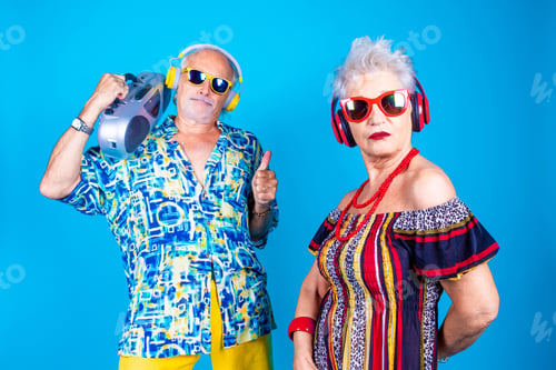 Preview: Couple of senior man and woman on blue background clubbing dancing having fun