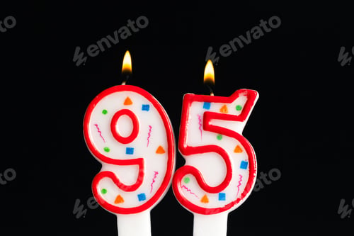 Preview: Celebrating a milestone birthday with 95 candle flames glowing on a festive cake