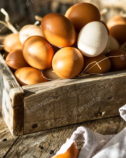 Preview: Fresh raw eggs in wooden box crate over wooden brown rustic background