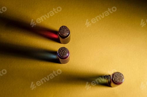 Preview: Small bottles with colorful liquid on a yellow surface closed by corks.