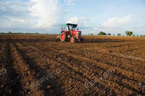 Preview: farmer with tractor preparing land for sowing with cultivator