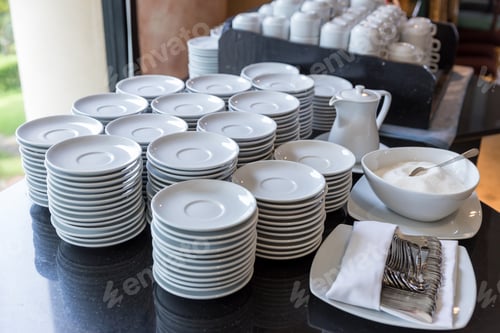 Preview: Bar counter with clean dish ready for work. Group of white plates stacked together in a hotel. Hotel