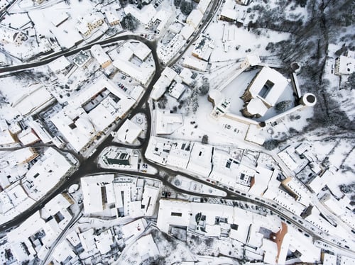 Preview: Aerial view of small town with hills in winter.