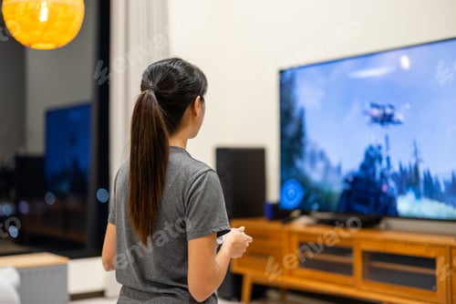 Preview: Woman play video game on TV at home