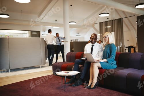 Preview: Diverse businesspeople working together on a sofa in an office