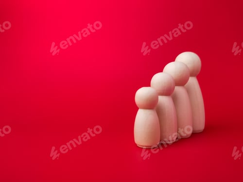 Preview: Wooden figures lined up according to their respective heights on red background with copy space.