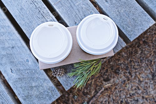 Preview: Top view of two cups of coffee to go take away in cardboard stand from the cafe on wooden background