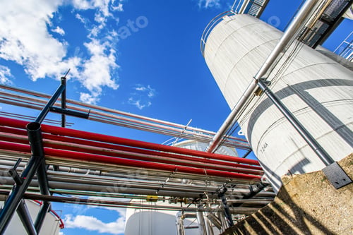 Preview: Low angle view of industrial piping and storage tanks at biofuel plant