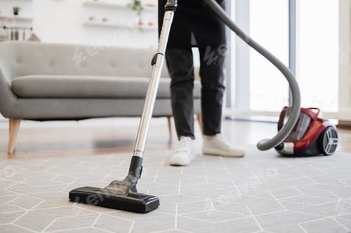 Preview: Cropped view of hands holding vacuum cleaner of female cleaning service worker.