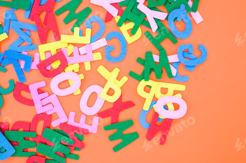 Preview: Top view closeup of the letters of the English alphabet isolated on an orange background