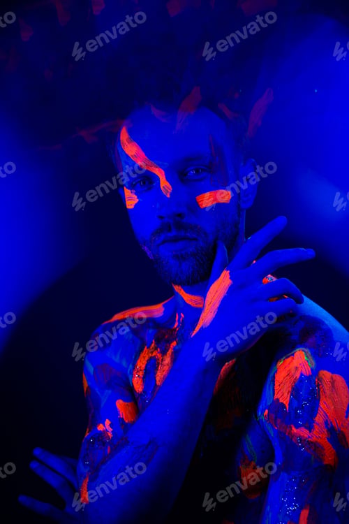 Preview: Portrait of a man with ultraviolet makeup and neon light in cyberpunk style.