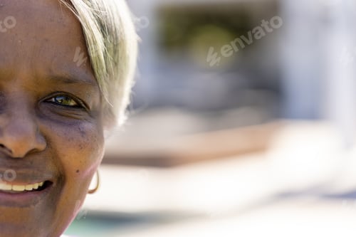 Preview: Half portrait of happy senior biracial woman smiling in sunny garden, copy space