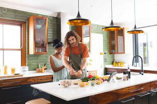 Preview: A diverse couple is preparing meal together in a modern kitchen