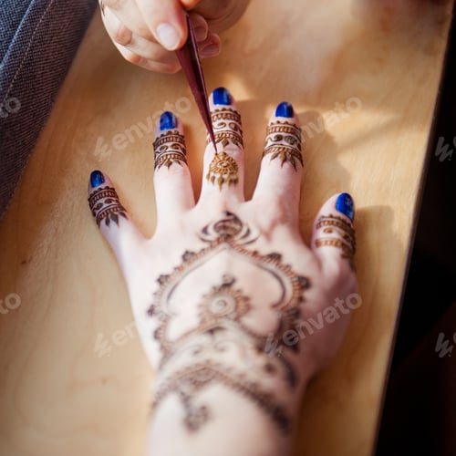 Preview: Drawing mehndi on the hand of a girl