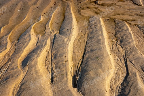 Preview: water rills on the shore of a beach during low tide at sunset