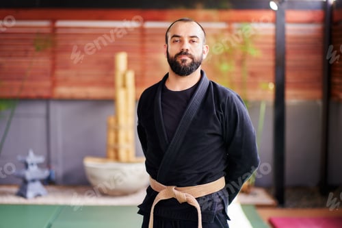 Preview: Martial arts master posing in his dojo, wearing a black kimono and brown belt