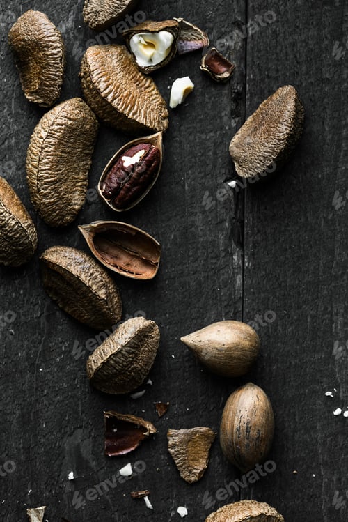 Preview: Raw Brazil and Pecan nuts in shell on Wooden Rustic table.