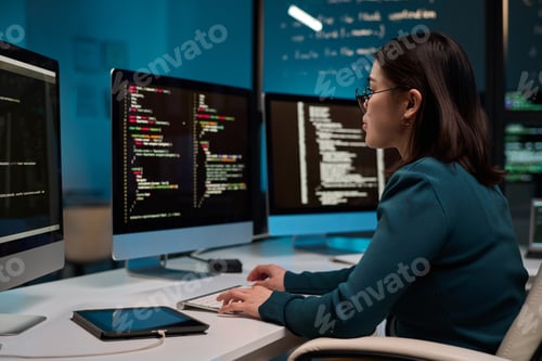 Preview: Girl as IT Developer Writing Code in Blue Light