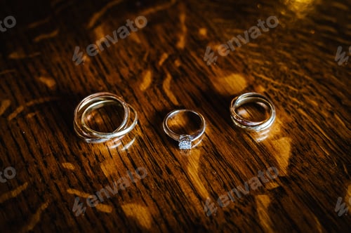 Preview: Beautiful golden wedding rings on a wooden background. Men's wedding ring. Women's ring.