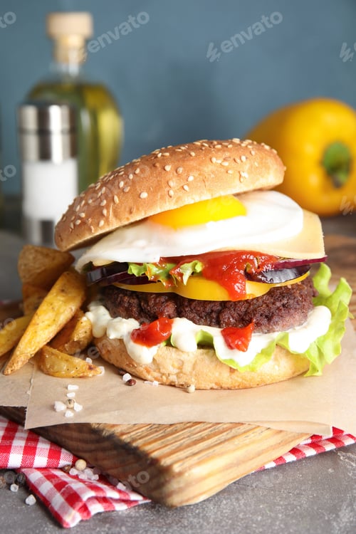 Preview: Tasty burger with fried egg on wooden board