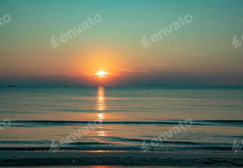 Preview: Turquoise sunrise on the calm ocean with sun just above the horizon