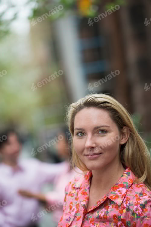 Preview: City life in spring. A woman with long blonde hair looking at the camera.