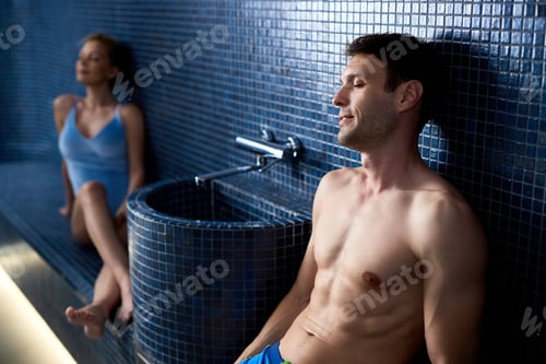 Preview: Relaxed man with eyes closed enjoying at steam sauna at the spa.