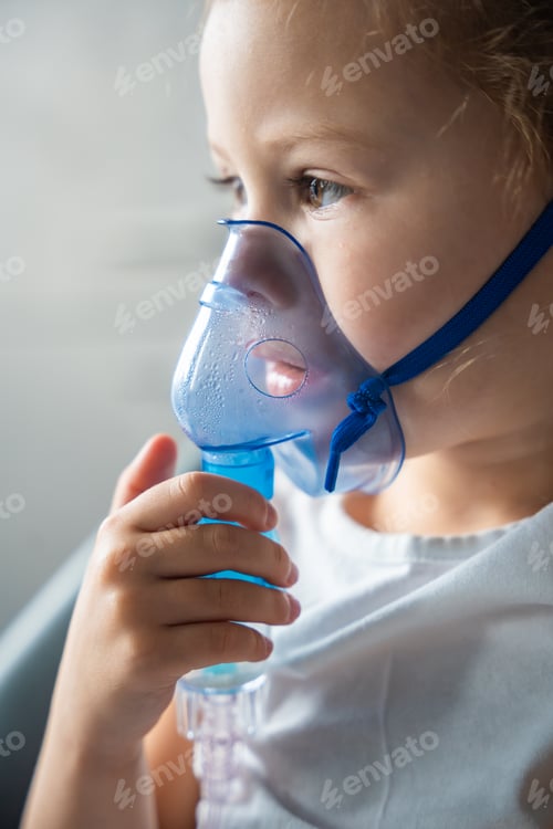 Preview: Close up view of little girl are sitting and holding a nebulizer mask leaning against the face
