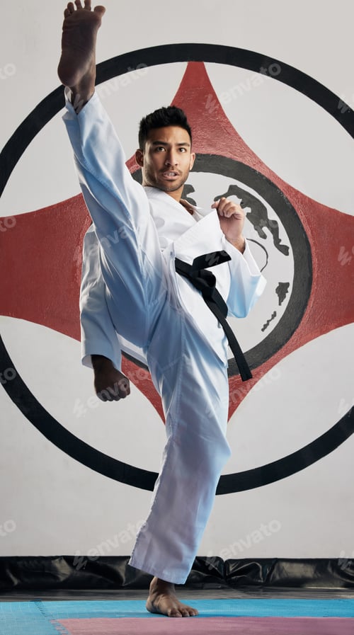 Preview: Kiai. Full length portrait of a handsome young martial artist practicing karate in his dojo.