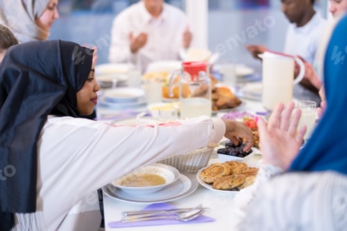 Preview: black modern muslim woman enjoying iftar dinner with family