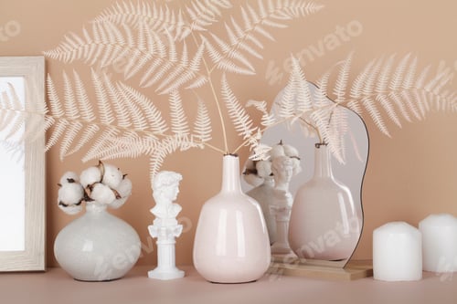 Preview: cozy and soft home decor concept. vases with dried grass, candles, small statue