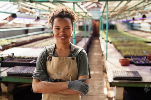 Preview: Happy young African-American female garden worker in workwear