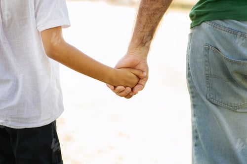 Preview: Old caucasian grandfather hold hand of little mixed race boy, enjoy free time, walk outdoor