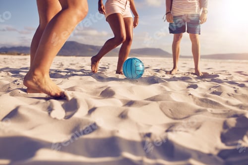 Preview: Friends playing soccer on the beach
