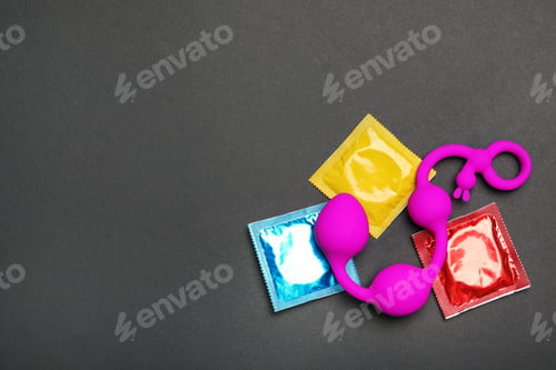 Preview: Anal balls and condoms on black background, top view with space for text. Sex game