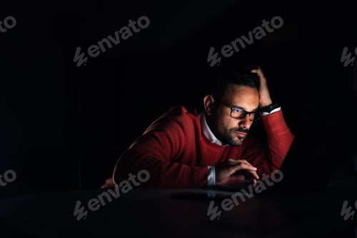 Preview: Businessman working late at the office, over the laptop.