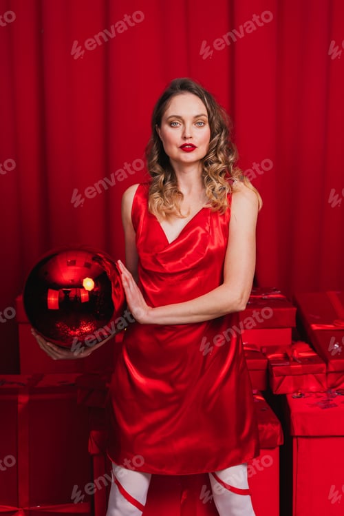 Preview: Beautiful young woman with red dress and gifts, christmas and festive days concepts