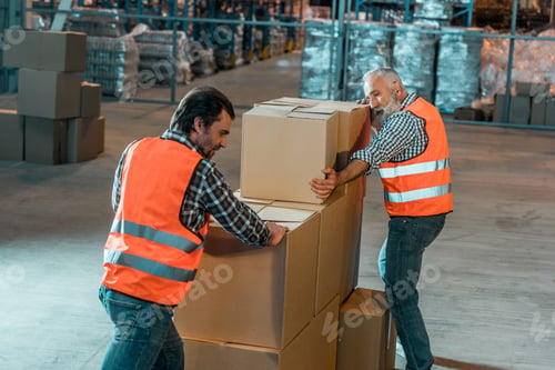 Preview: warehouse workers in vests moving boxes in storehouse